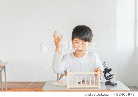 在學校課堂上進行科學實驗、觀察、研究和學習的小學生（顯微鏡、試管、滴管） 98403978