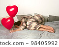 Depressed woman with an inflatable balloon on Valentine's Day. Front view.  98405992