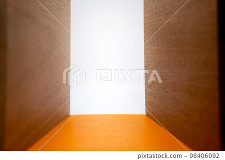 The background is surrounded by wooden walls and light shines through a narrow orange road leading to the back. 98406092