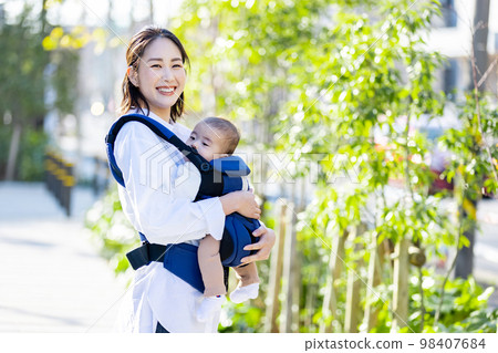 一個年輕的女人，撫養著一個擁抱的孩子 98407684