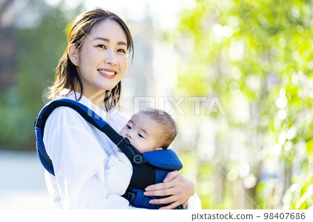 一個年輕的女人，撫養著一個擁抱的孩子 98407686