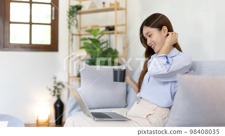 Woman using laptop to work or do homework at home with smiling face in her living room, Creating happiness at work with a smile, Live performance or video call with laptop, Work from home. Woman using laptop to work or do homework at home with smiling face in her living room, Creating happiness at work with a smile, Live performance or video call with laptop, Work from home. 98408035