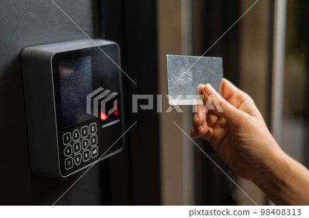 A woman opens the door with a plastic card. Modern keyless entry lock.  98408313