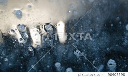 Detergent, foam and water on the windshield of a car being washed Detergent, foam and water on the windshield of a car being washed 98408398