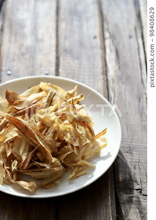 Gluten-free vegetable snack: sliced burdock chips Gluten-free vegetable snack: sliced burdock chips 98408629