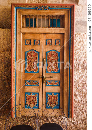 An old historical stone wall with a wooden door gate in Antalya Old town Kaleici, Turkey. 98409930