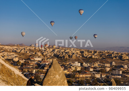 Cappadocia. View of Goreme town with caves and hot air balloons in Cappadocia. Turkey. 98409935