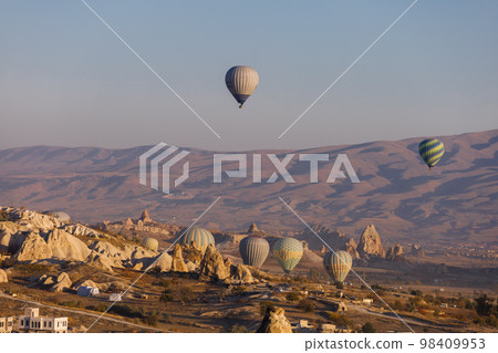 Cappadocia. View of Goreme town with caves and hot air balloons in Cappadocia. Turkey. Cappadocia. View of Goreme town with caves and hot air balloons in Cappadocia. Turkey. 98409953