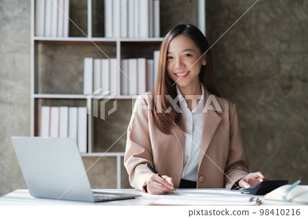 Asian Business woman working at home office and analyze financial report document. Accounting and Finance concept Asian Business woman working at home office and analyze financial report document. Accounting and Finance concept 98410216