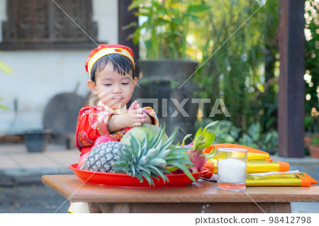 Asian baby boy with traditional Chinese outfit. prepare fruit for offerings Chinese God. Asian baby boy with traditional Chinese outfit. prepare fruit for offerings Chinese God. 98412798
