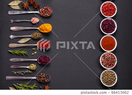 Composition consisting of variations of spices in white bowls and metal spoons 98413002