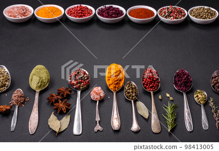 Composition consisting of variations of spices in white bowls and metal spoons 98413005