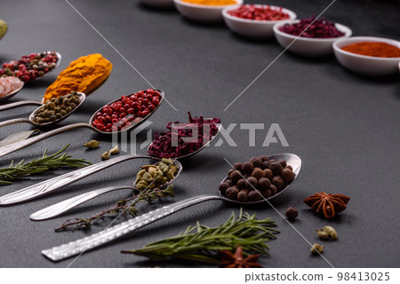 Composition consisting of variations of spices in white bowls and metal spoons 98413025