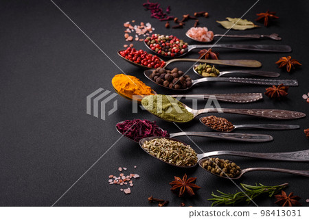 Composition consisting of variations of spices in white bowls and metal spoons 98413031