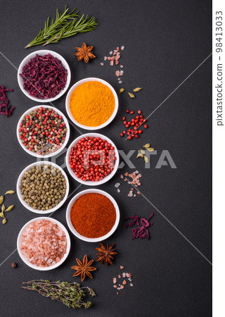 Composition consisting of variations of spices in white bowls and metal spoons Composition consisting of variations of spices in white bowls and metal spoons 98413033