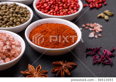 Composition consisting of variations of spices in white bowls and metal spoons 98413043