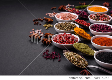 Composition consisting of variations of spices in white bowls and metal spoons Composition consisting of variations of spices in white bowls and metal spoons 98413068