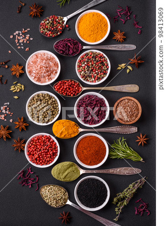 Composition consisting of variations of spices in white bowls and metal spoons Composition consisting of variations of spices in white bowls and metal spoons 98413069