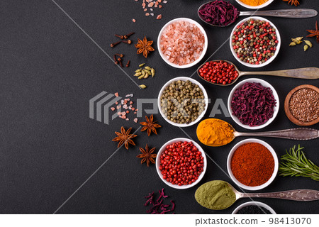 Composition consisting of variations of spices in white bowls and metal spoons Composition consisting of variations of spices in white bowls and metal spoons 98413070