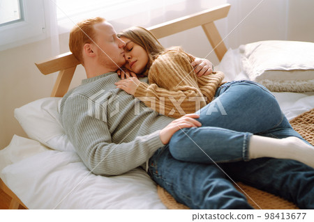 Couple in love relaxing at home on bed while they hug each other. Valentine's Day, holiday concept. Couple in love relaxing at home on bed while they hug each other. Valentine's Day, holiday concept. 98413677