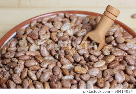Dry Pinto Beans in Clay Bowl With Wooden Spoon in Rustic Kitchen Dry Pinto Beans in Clay Bowl With Wooden Spoon in Rustic Kitchen 98414034