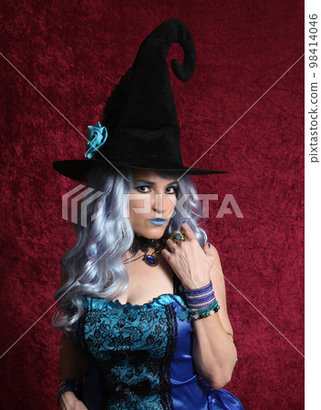 Woman Dressed as Blue Witch on Red Background 98414046