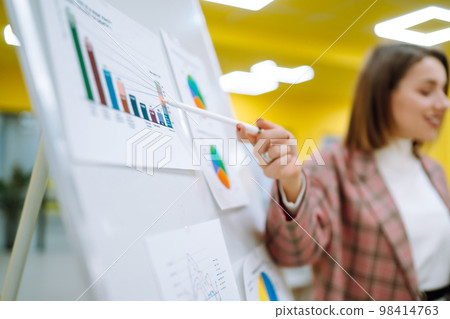 Young woman leader, presenter, make a business presentation at a conference in the office. 98414763