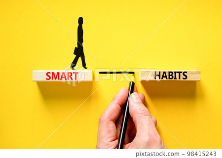 Smart habits symbol. Concept words Smart habits on wooden blocks. Beautiful yellow table yellow background. Businessman hand. Businesswoman icon. Business and smart habits concept. Copy space. 98415243