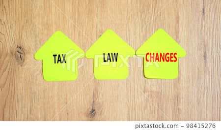 Tax law changes symbol. Concept words Tax law changes on green paper houses on a beautiful wooden table wooden background. Business tax law changes concept. Copy space. Tax law changes symbol. Concept words Tax law changes on green paper houses on a beautiful wooden table wooden background. Business tax law changes concept. Copy space. 98415276