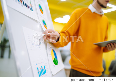 Young man leader, presenter, make a business presentation at a conference in the office. Young man leader, presenter, make a business presentation at a conference in the office. 98415297