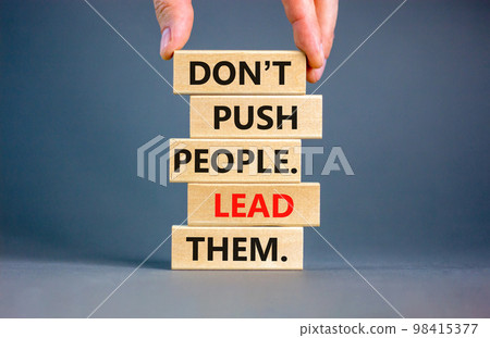 Push or lead people symbol. Concept words Do not push people lead them on wooden blocks. Beautiful grey table grey background. Businessman hand. Business Push or lead people concept. Copy space. 98415377