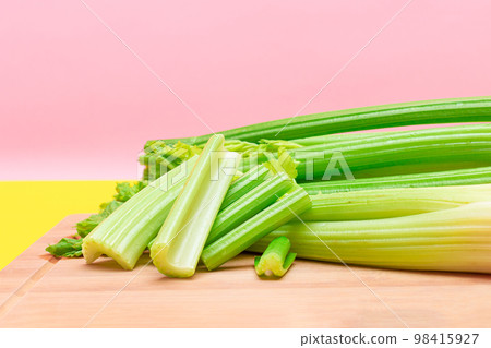 Fresh Celery Stem and Chopped Celery Sticks on Wooden Cutting Board Fresh Celery Stem and Chopped Celery Sticks on Wooden Cutting Board 98415927
