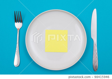 Colored Sticky Note or Memo Paper on White Ceramic Plate 98415946