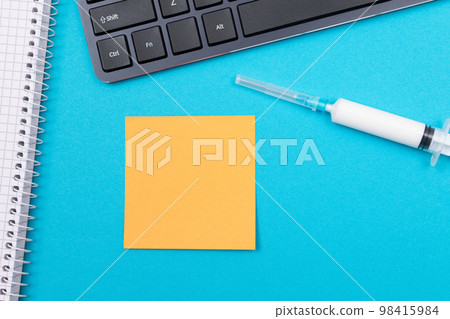 Vaccination or Revaccination Concept - A Medical Syringe on Blue Table Vaccination or Revaccination Concept - A Medical Syringe on Blue Table 98415984