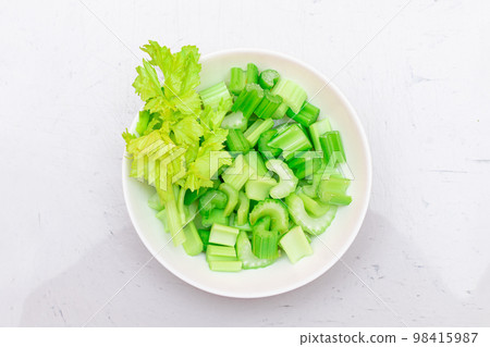 Fresh Chopped Celery Slices with Water Drops on White Dish - Top View Fresh Chopped Celery Slices with Water Drops on White Dish - Top View 98415987