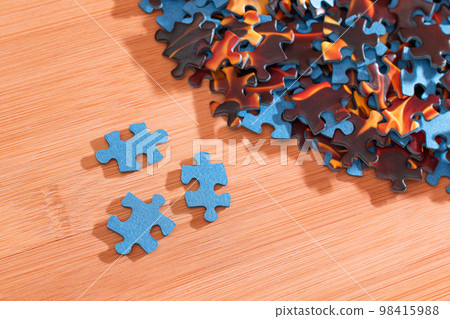Mixed Jigsaw Puzzle Peaces on Wooden Table Mixed Jigsaw Puzzle Peaces on Wooden Table 98415988