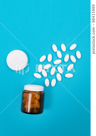 Pharmaceutical Industry and Medicinal Products - White Pills on Blue Table Pharmaceutical Industry and Medicinal Products - White Pills on Blue Table 98415989