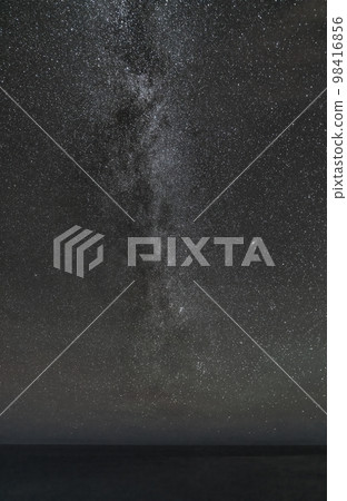 Milky way over the calm plain ocean with text space 98416856
