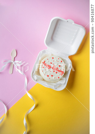A small bento birthday cake in a box. Wooden boat with white ribbon A small bento birthday cake in a box. Wooden boat with white ribbon 98416877