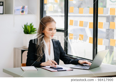 Woman freelancer is working her job on computer tablet and laptop Doing accounting analysis report real estate investment data, Financial at office... 98417900