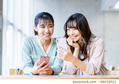 College girl looking at a smartphone College girl looking at a smartphone 98418022