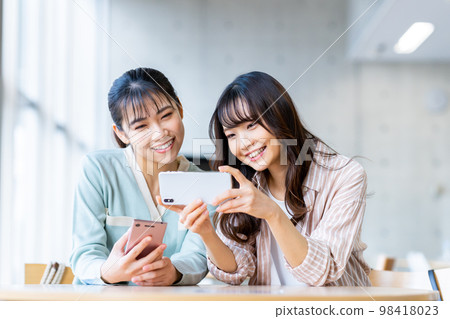 College girl looking at a smartphone College girl looking at a smartphone 98418023