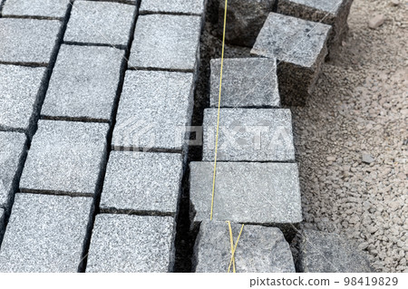 Construcion site of pavement granite cobblestone road in old city center installation or renovation repair. Roadworks stonework at pedestrian area. Paved sidewalk reconstruction. Urban development Construcion site of pavement granite cobblestone road in old city center installation or renovation repair. Roadworks stonework at pedestrian area. Paved sidewalk reconstruction. Urban development 98419829