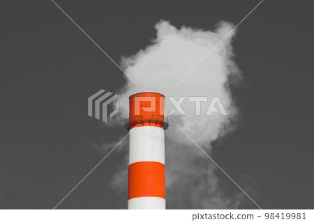 Pollution of the environment, ecology and air. Withdrawal of combustion products of soot, smoke and gases from the pipe of an industrial plant into the atmosphere against the background of a gray sky Pollution of the environment, ecology and air. Withdrawal of combustion products of soot, smoke and gases from the pipe of an industrial plant into the atmosphere against the background of a gray sky 98419981