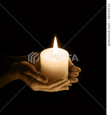 Women's hands holding a candle Women's hands holding a candle 98420314