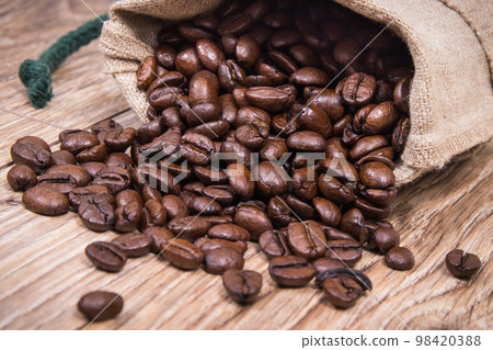 Dark roasted fragrant coffee beans in jute bag Dark roasted fragrant coffee beans in jute bag 98420388
