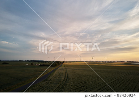 Aerial view of windmill turbine generator against beautiful sunset sky in countryside area, Concept of clean, renewable, sustainable, alternative energy 98420924
