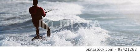 Athletic man jumping on kite surf board on a sea waves. Kiteboarding man among waves quickly goes. Watersport adrenaline fun adventure acitivity Athletic man jumping on kite surf board on a sea waves. Kiteboarding man among waves quickly goes. Watersport adrenaline fun adventure acitivity 98421268