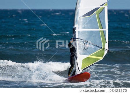 Windsurfer surfing the wind on waves in ocean sea. Recreational sporting activity Windsurfer surfing the wind on waves in ocean sea. Recreational sporting activity 98421270