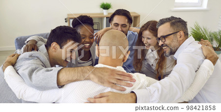 Happy business team hugging in circle rejoicing and celebrating successful work result. 98421858